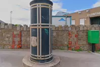 A FREESTANDING FINIAL-TOPPED CAST-IRON TRANSFORMER [DATING FROM 1900 AND LOCATED AT CONQUER HILL ROAD NEAR CLONTARF BUS GARAGE]-244412-1