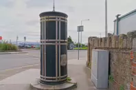 A FREESTANDING FINIAL-TOPPED CAST-IRON TRANSFORMER [DATING FROM 1900 AND LOCATED AT CONQUER HILL ROAD NEAR CLONTARF BUS GARAGE]-244415-1