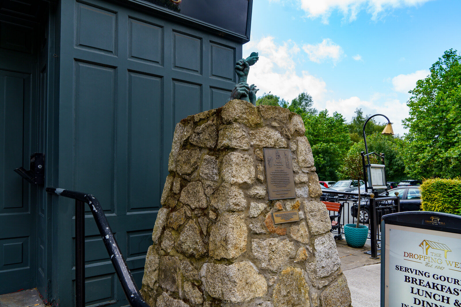 FAMINE MEMORIAL BY SCULPTOR JOHN MC KENNA [AT THE ENTRANCE TO THE DROPPING WELL PUB IN MILLTOWN]-239260-1